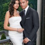 Elegant couple in formal attire on balcony